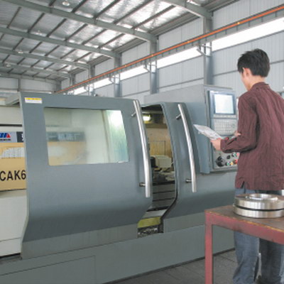 CNC lathe with operator checking the program.