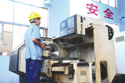 CNC machine with pendant control and operator.
