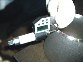 Digital micrometer measuring wall thickness.