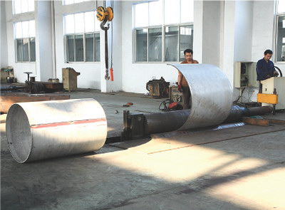Plate rolling machine with rolled stainless shells.