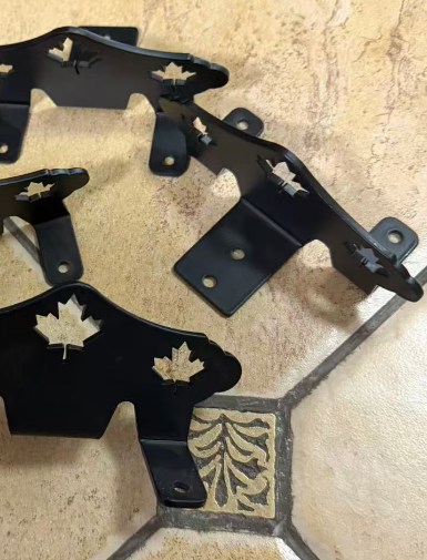 Black powder-coated snow guard brackets with maple leaf cutout.